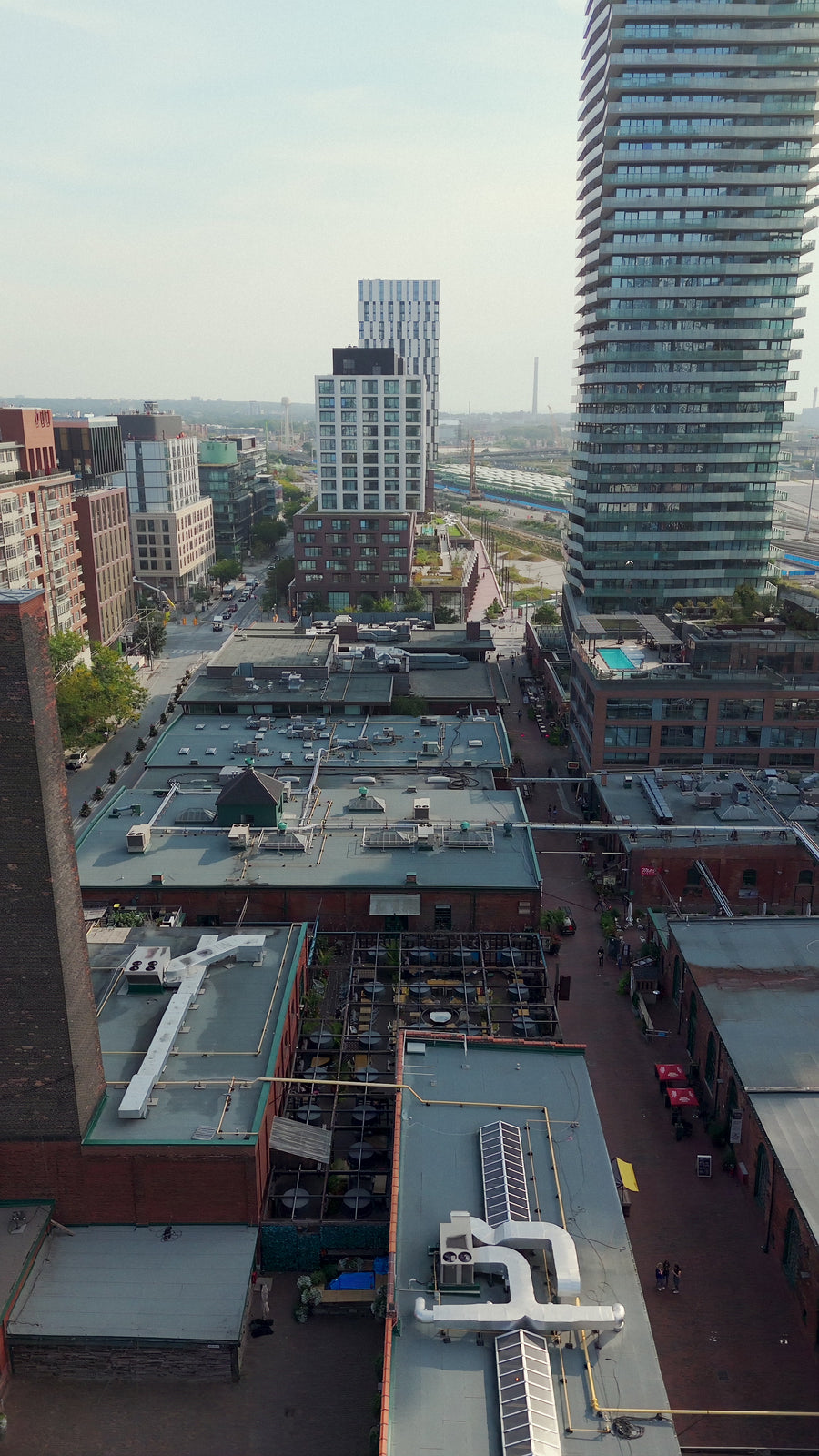 Industrial Rooftops with City Skyline - Pan Aerial