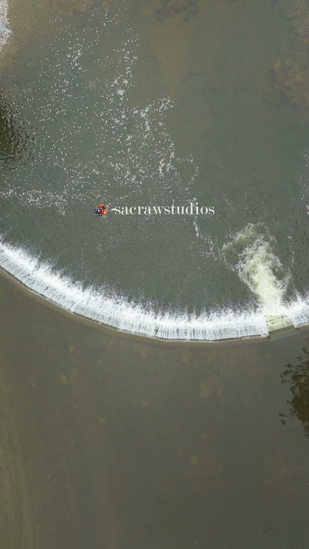 Aerial Pullup of River Weir with Water Flowing Over
