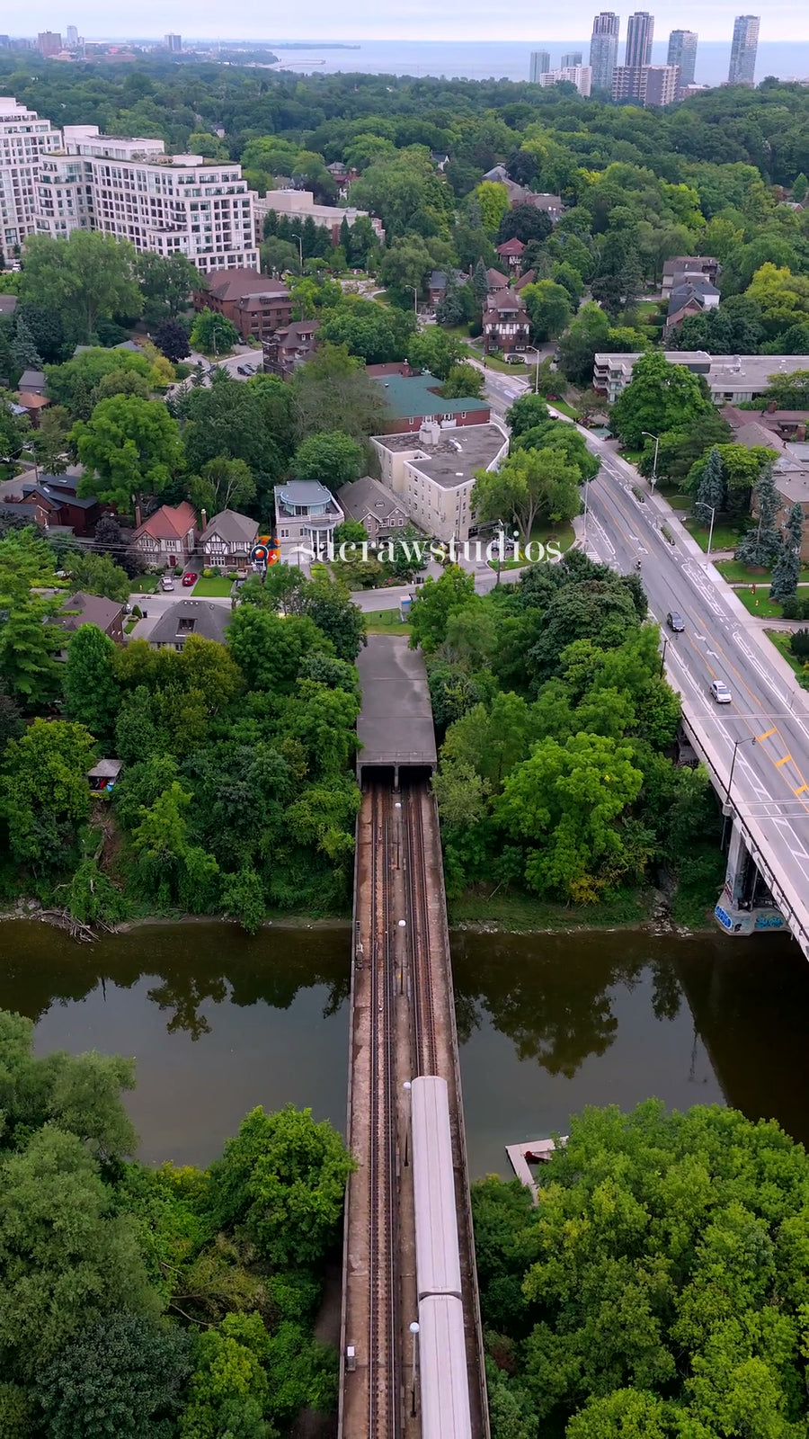 Train Entering Tunnel over River Bridge - Aerial