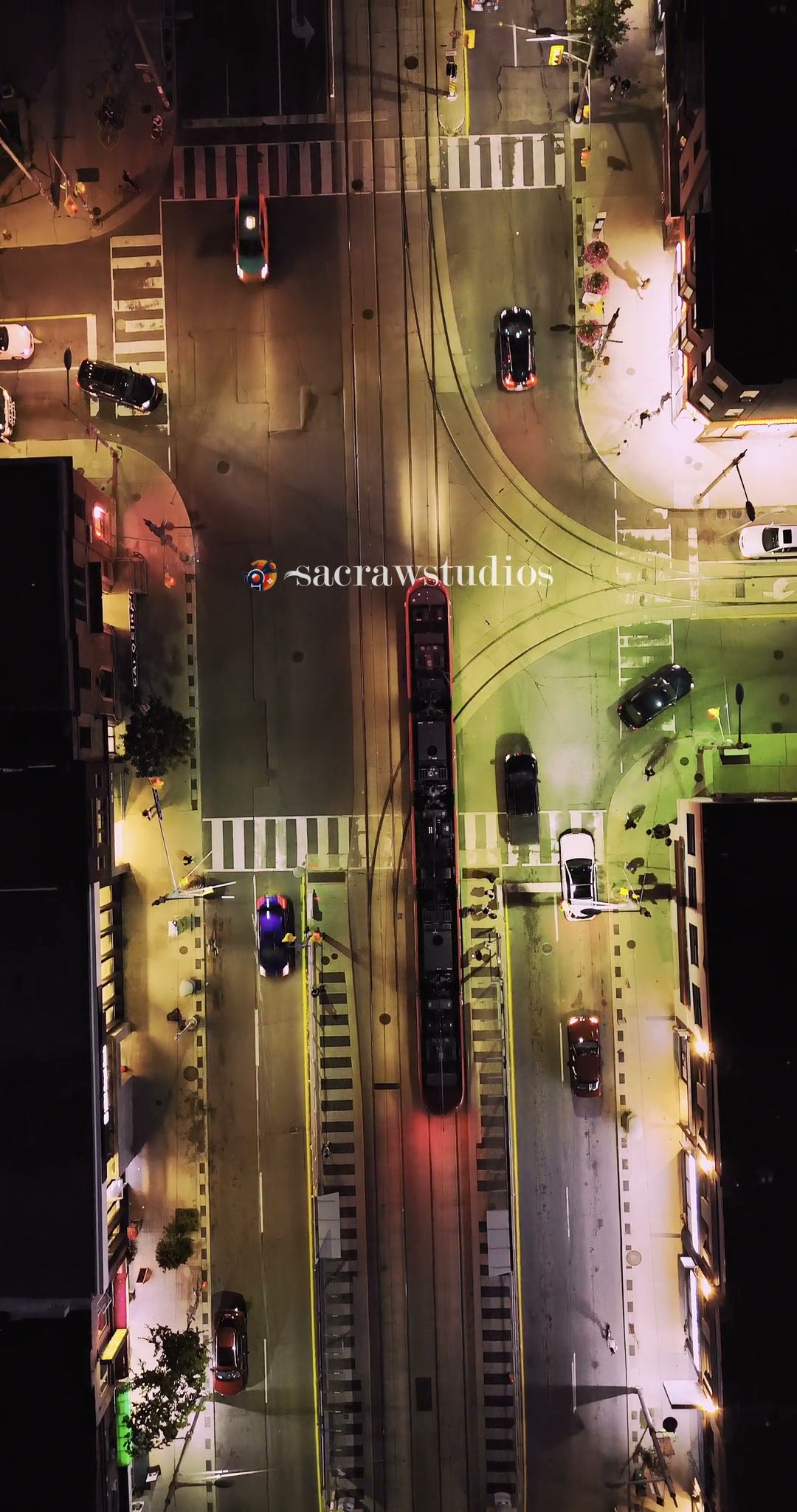 Aerial view of tram and cars at night urban intersection