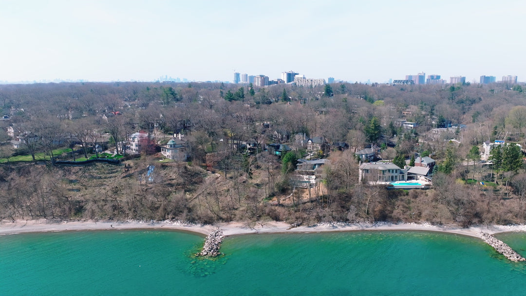 Aerial View of Lakefront Luxury Homes with City Skyline in Distance — Premium 8K stock footage