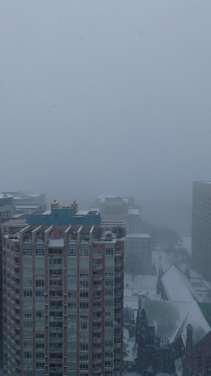 Snowy Cityscape with Falling Snow - Aerial Pullback