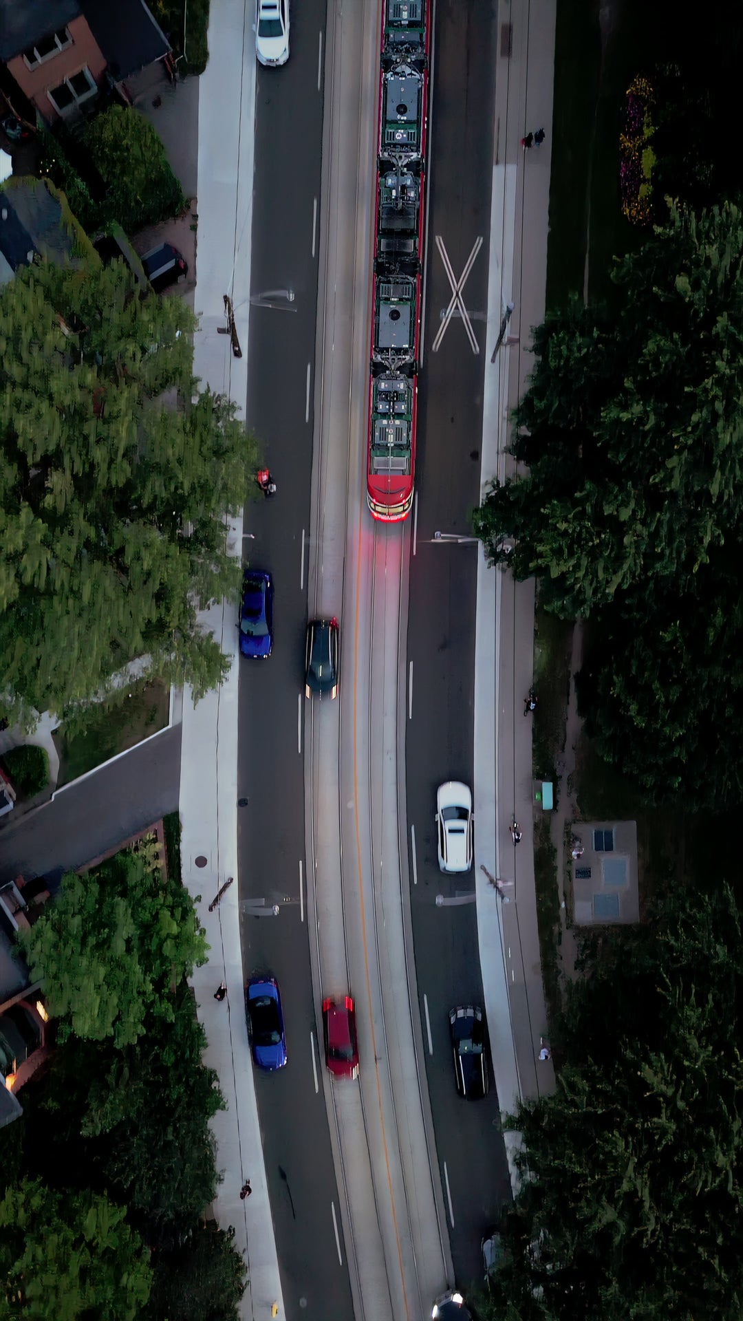 Streetcar on Curving Tree - Lined Road at Dusk - Aerial — 4K stock footage