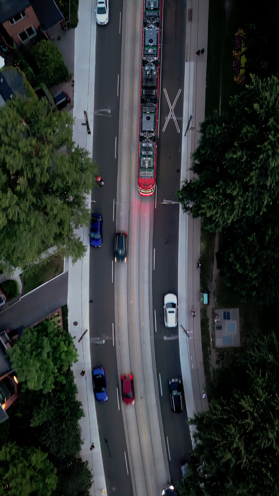 Streetcar on Curving Tree-Lined Road at Dusk - Aerial