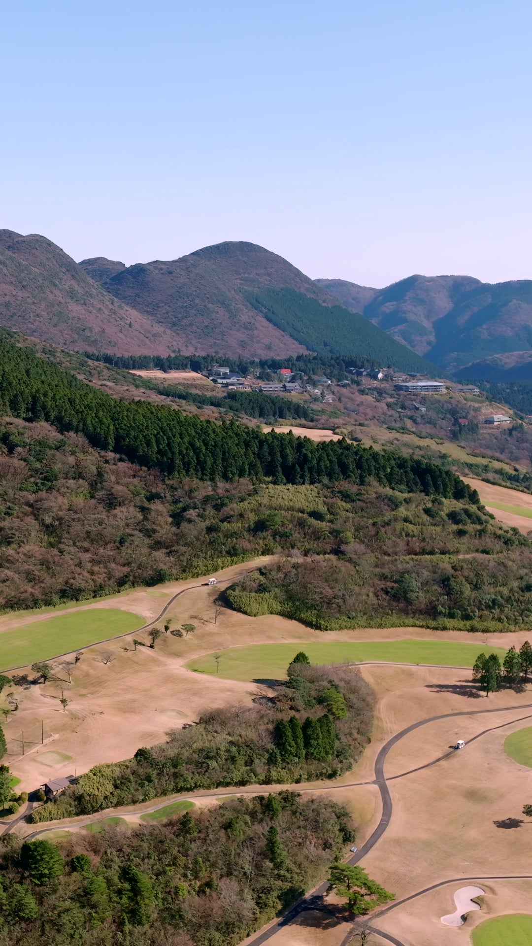 Aerial View of Mountain Golf Course with Cart on Winding Path — Premium 4K stock footage
