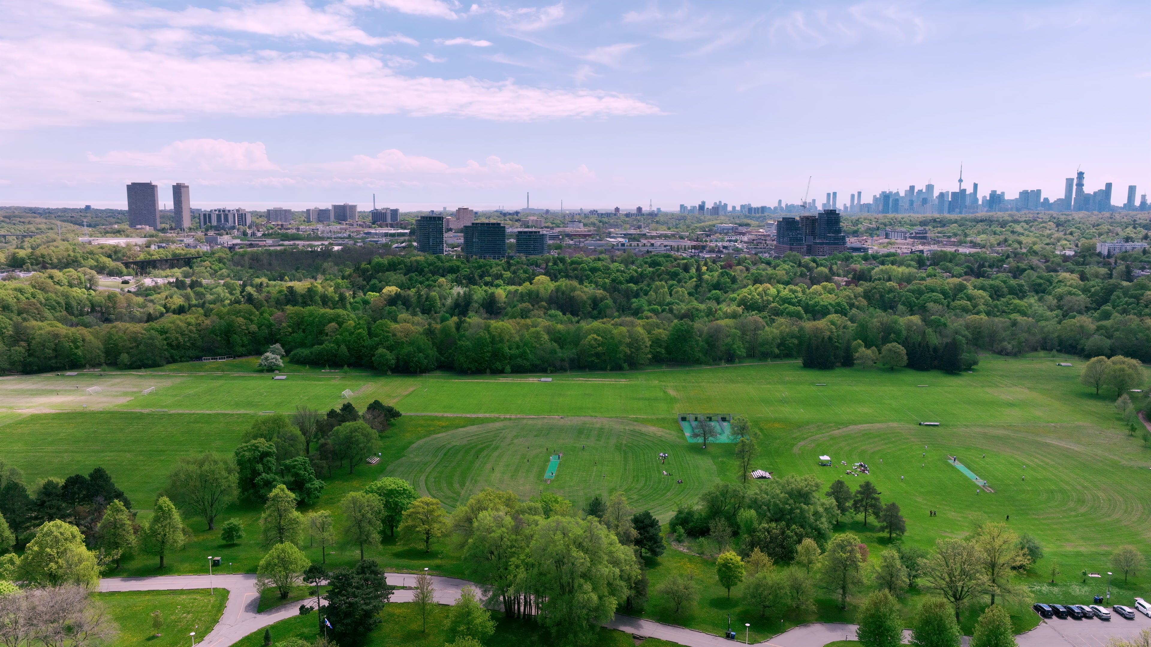 Lush Green Park with City Skyline - Aerial in summer — 4K stock footage