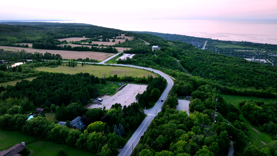 Rural Road Through Green Hills at Dusk - Aerial