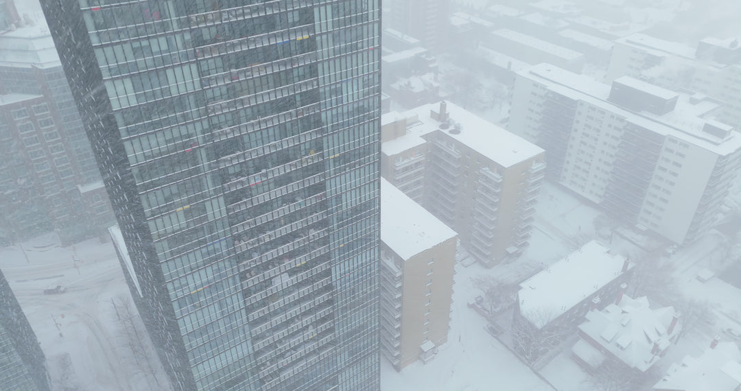 Aerial View of Snow-Covered Modern Cityscape During Heavy Snowstorm — Premium 4K stock footage