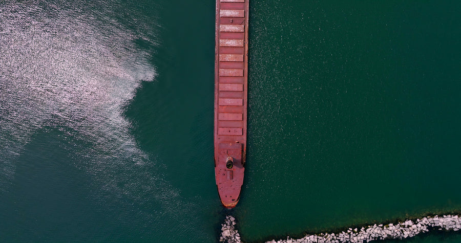 Aerial Top View of Cargo Ship Sailing Through Harbor