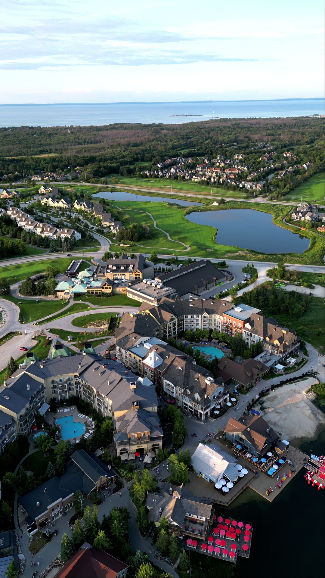 Luxury Lakeside Resort Village with Golf Course at Sunset - Aerial in Canada at golden hour — 4K stock footage