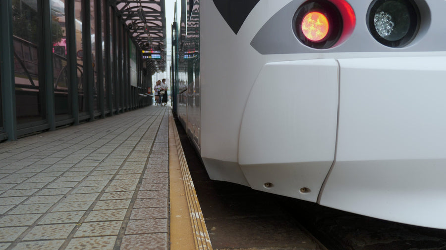 Modern Tram at Station Platform with Passengers Walking