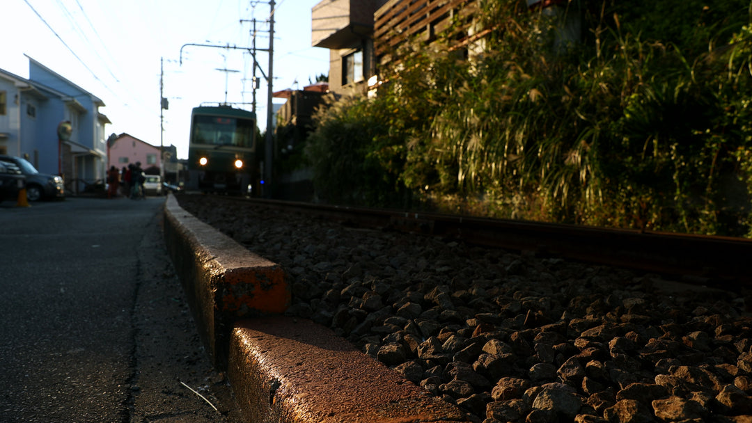 Japanese Local Train Passing Through Residential Neighborhood at Sunset at golden hour — 4K stock footage