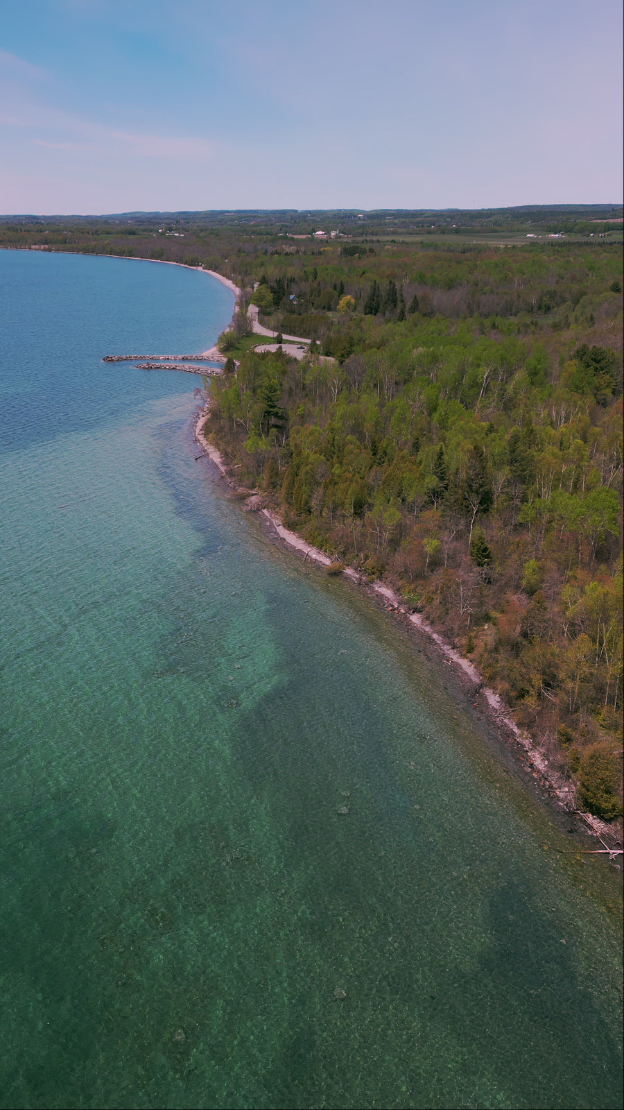Turquoise Lake Shoreline with Forest and Rocky Beach - Aerial