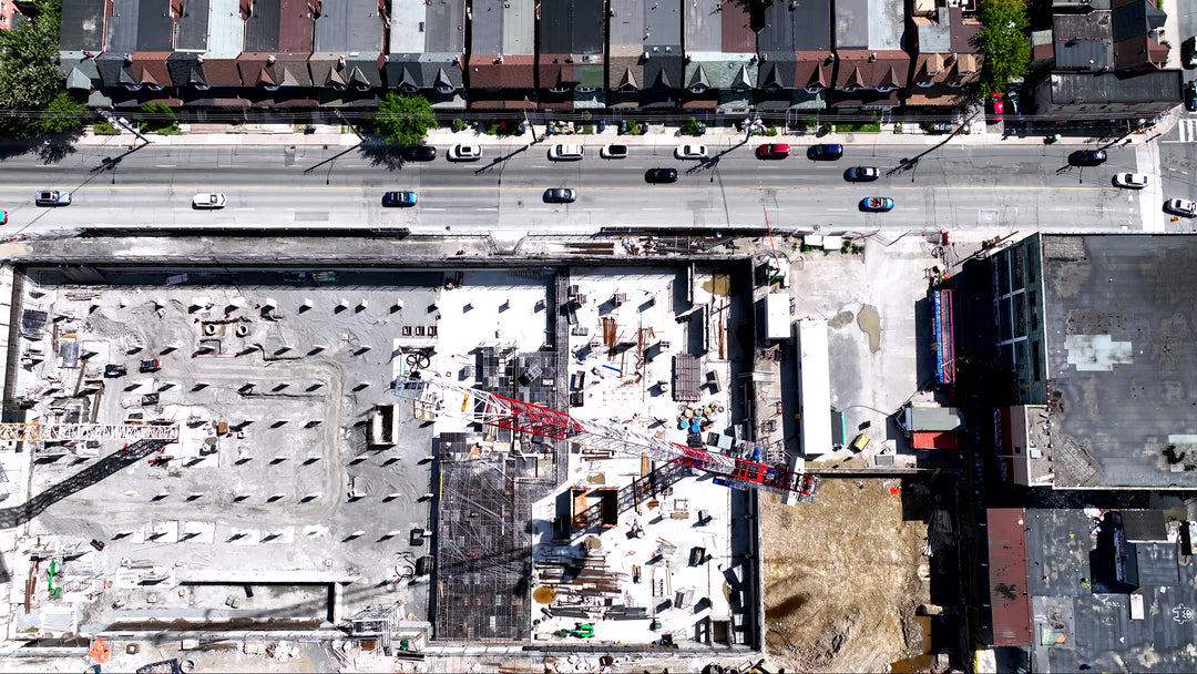 Aerial Top Down View of Urban Construction Site with Crane and Traffic — Premium 4K stock footage