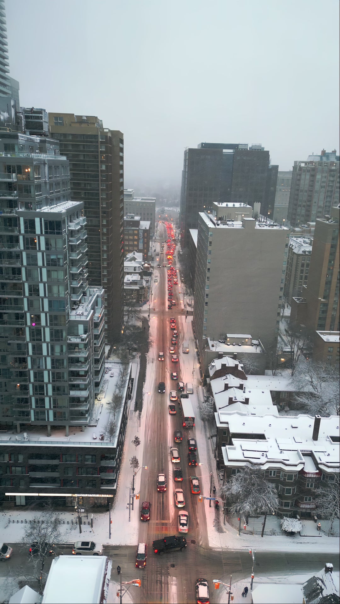 Aerial View Snowy City Street with Traffic and Skyscrapers in Winter