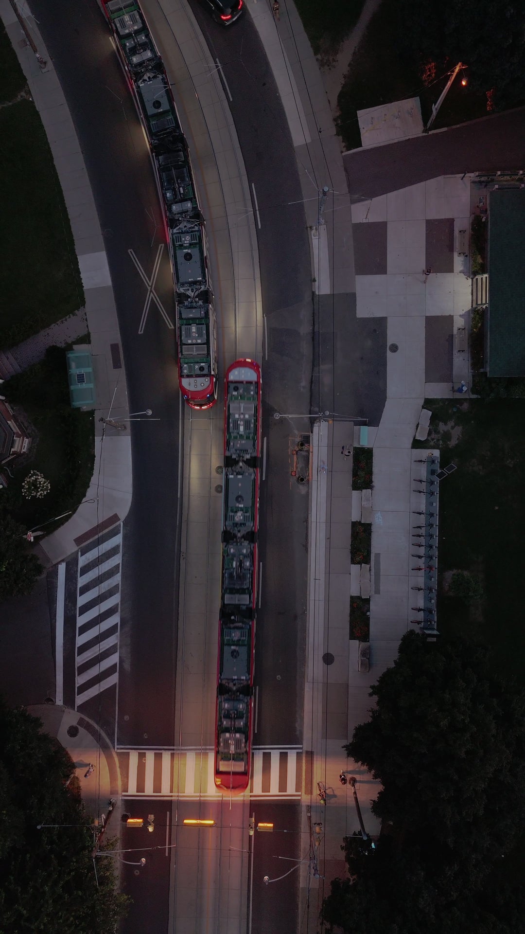 Aerial Top Down View of Red Trams at Dusk in Urban Setting — Premium 4K stock footage