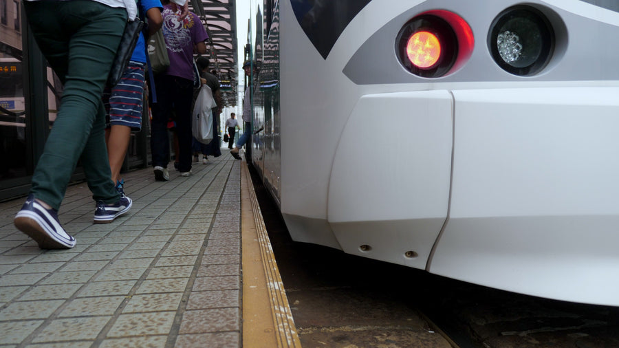 Passengers Boarding Modern Tram at Station Platform - Low Angle