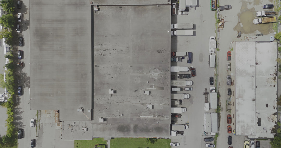 Aerial Top Down View of Industrial Warehouse Rooftops and Parking Lot — Premium 4K stock footage