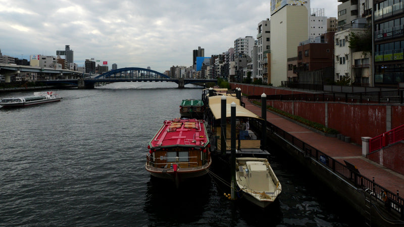 Tokyo River Waterfront with Boats and Bridge at Dusk
