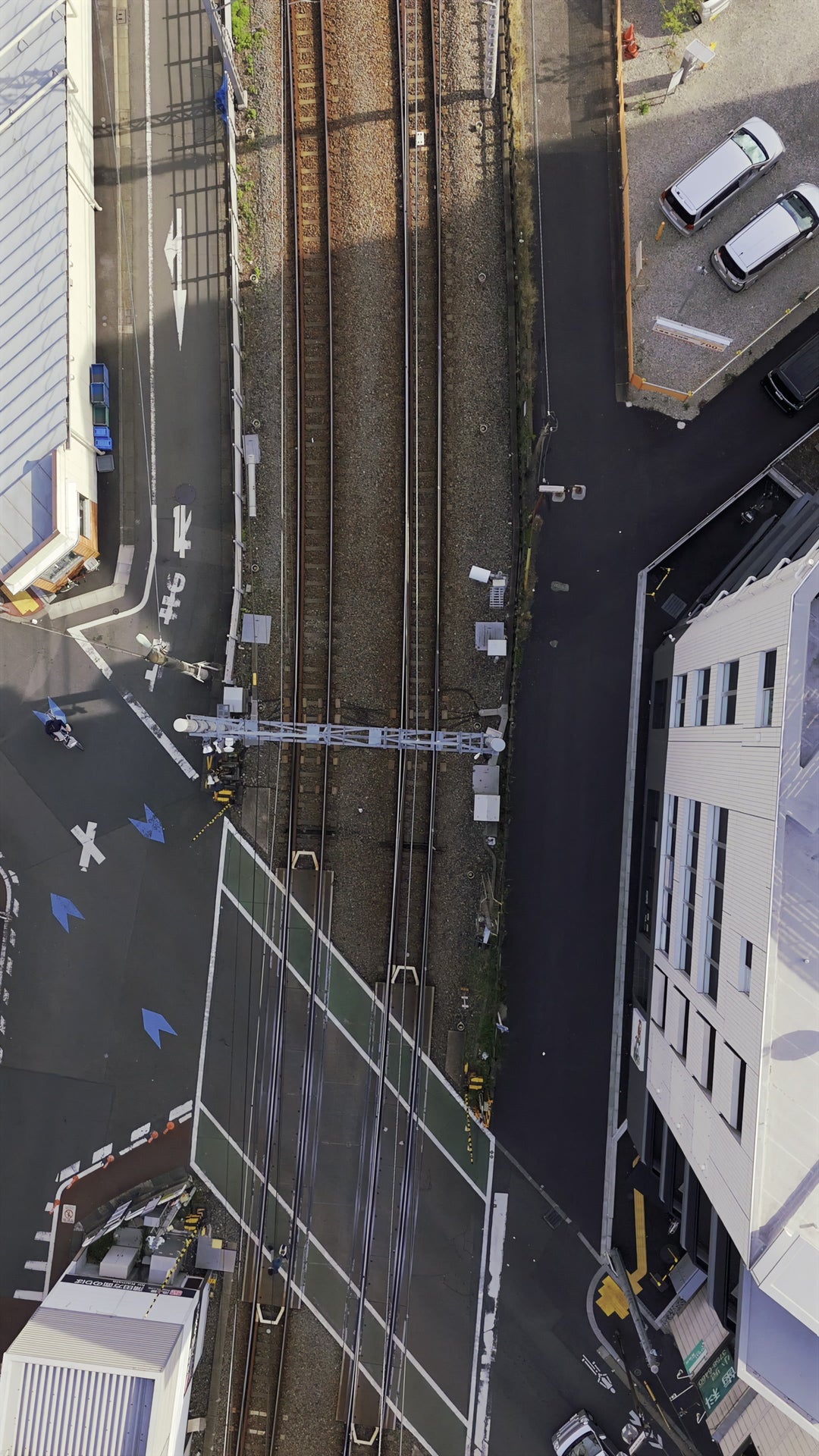 Aerial Top-Down View of Urban Railroad Crossing with Traffic — Premium 4K stock footage
