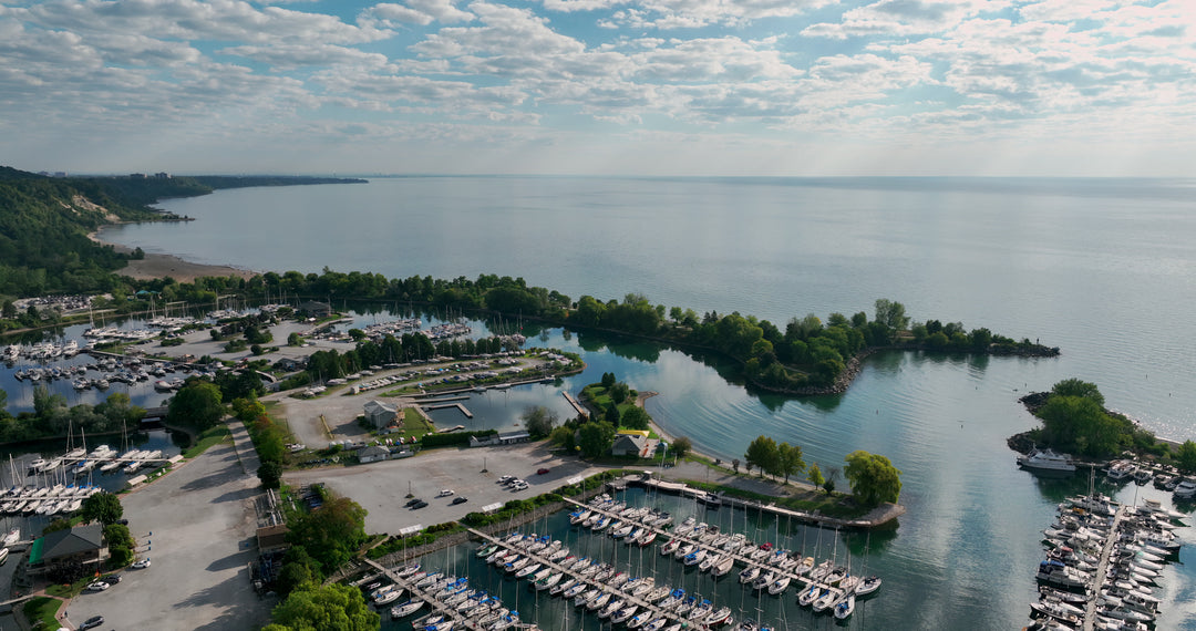Aerial View of Coastal Marina with Docked Sailboats and Calm Harbor Waters — Premium 4K stock footage