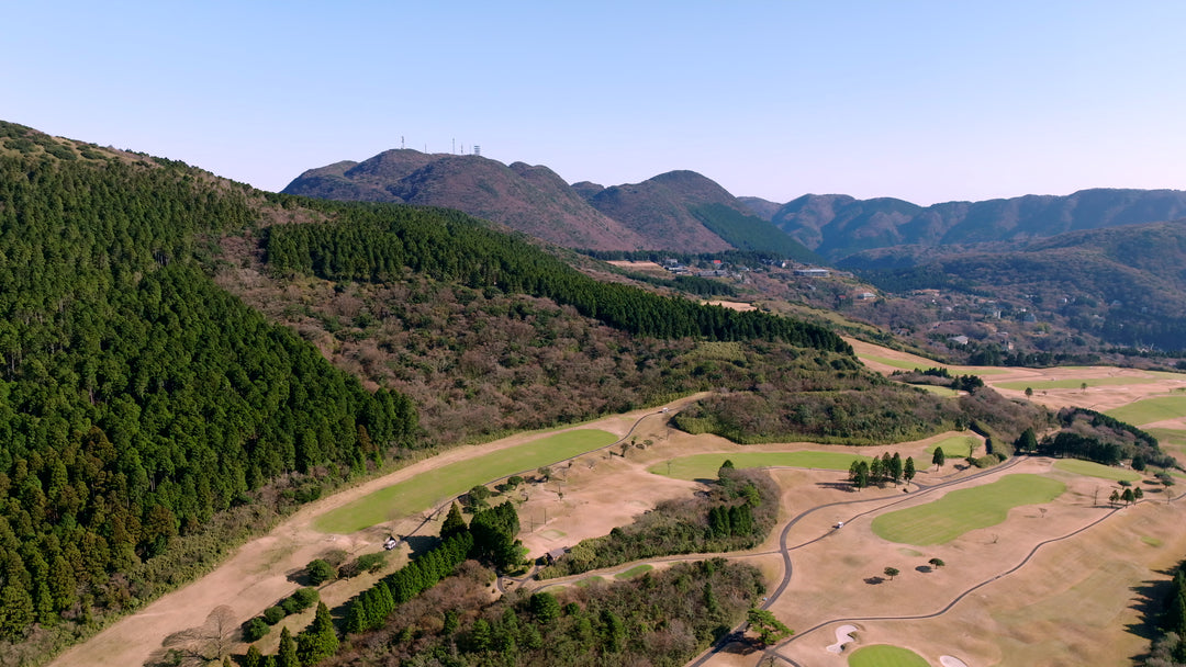 Aerial View of Mountain Golf Course with Lush Forest and Rolling Hills — Premium 4K stock footage