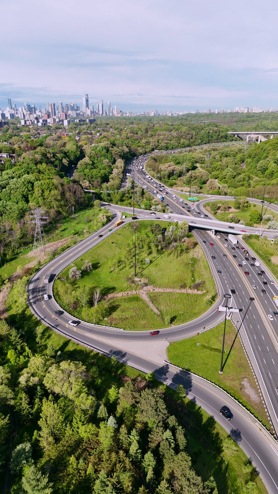 Highway Interchange with City Skyline - 4K Aerial