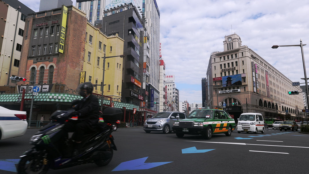 Busy Tokyo Street Intersection with Traffic and Historic Buildings