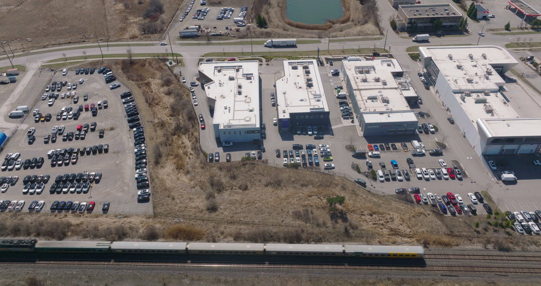 Aerial View of Freight Train Passing Industrial Park with Parking Lots — Premium 4K stock footage