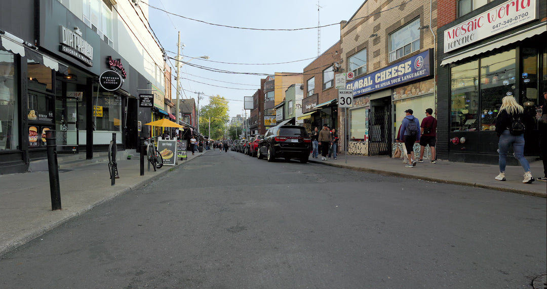 Pedestrians Walking Along Bustling Urban Shopping Street with Storefronts