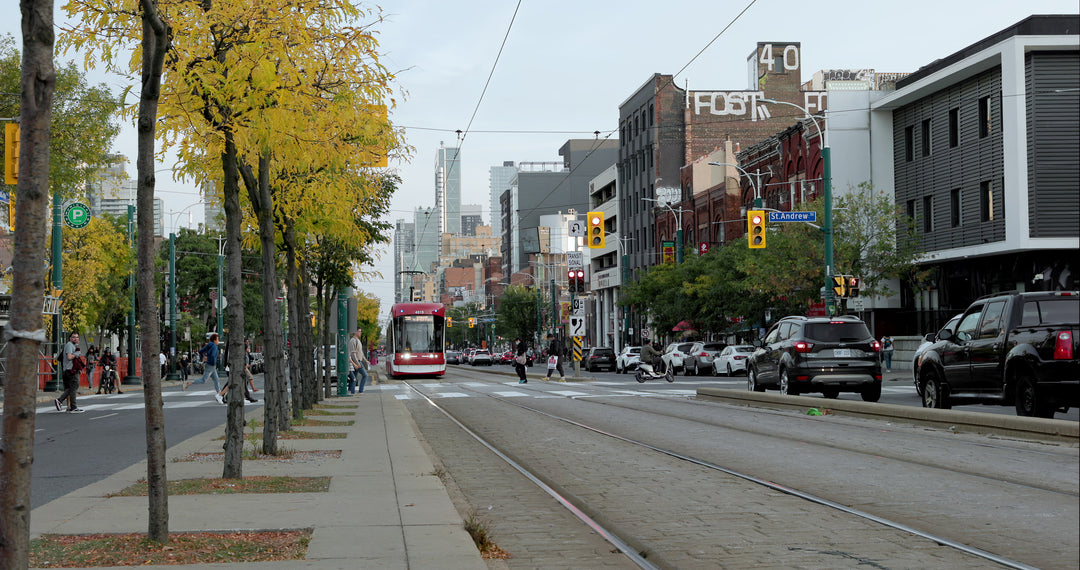 Red Streetcar Approaching on Toronto City Street with Autumn Trees