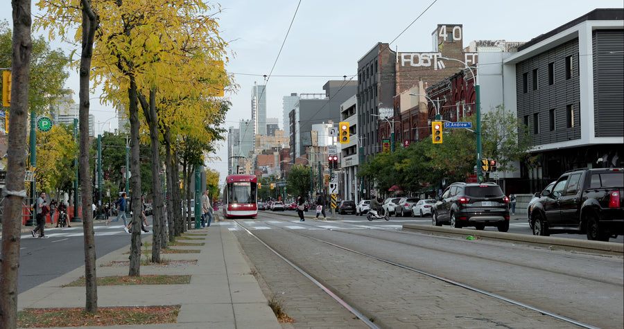 Red Streetcar Approaching on Toronto City Street with Autumn Trees