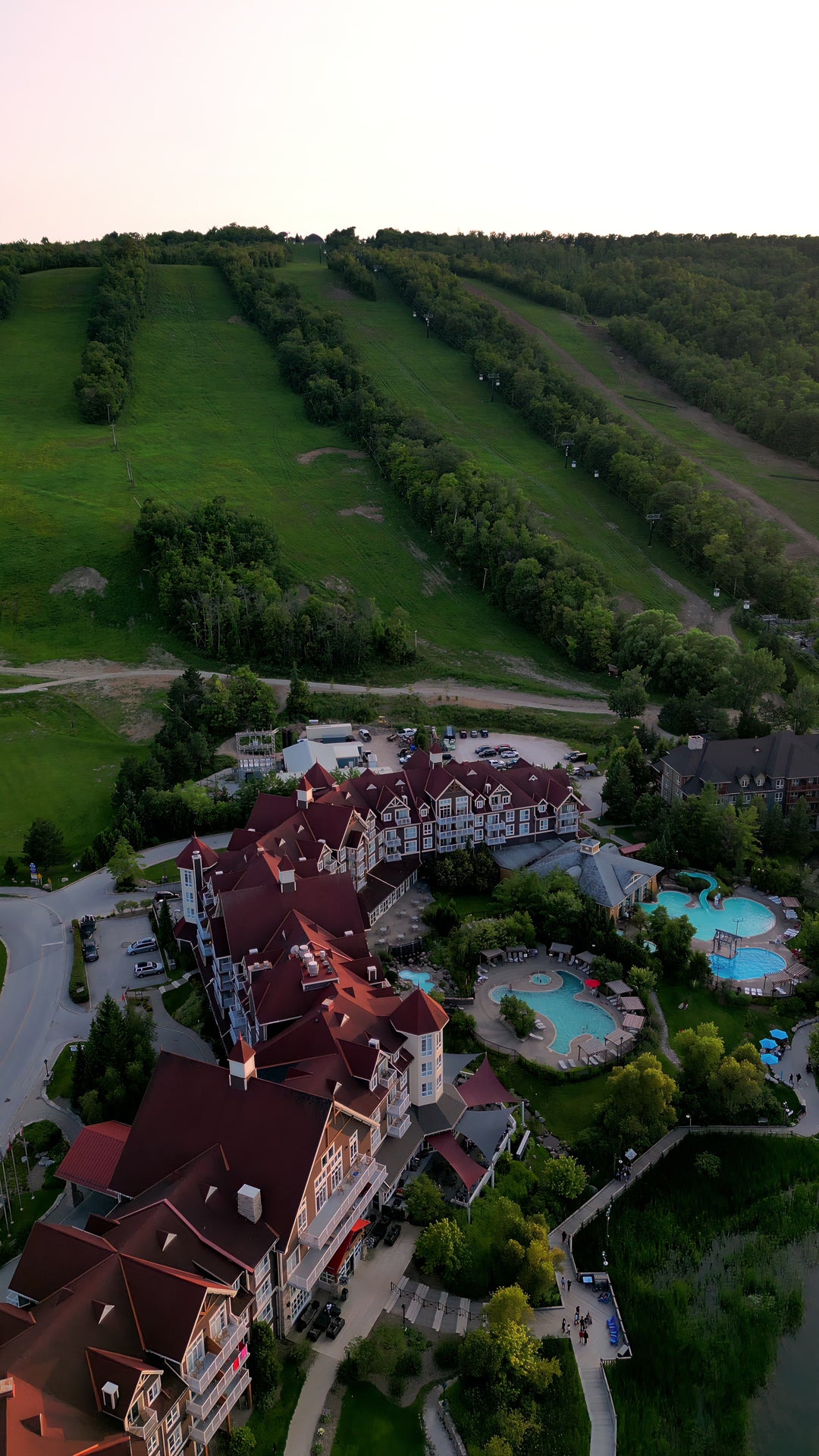 Luxury Mountain Resort with Golf Course at Sunset - Aerial in Canada at golden hour — 4K stock footage