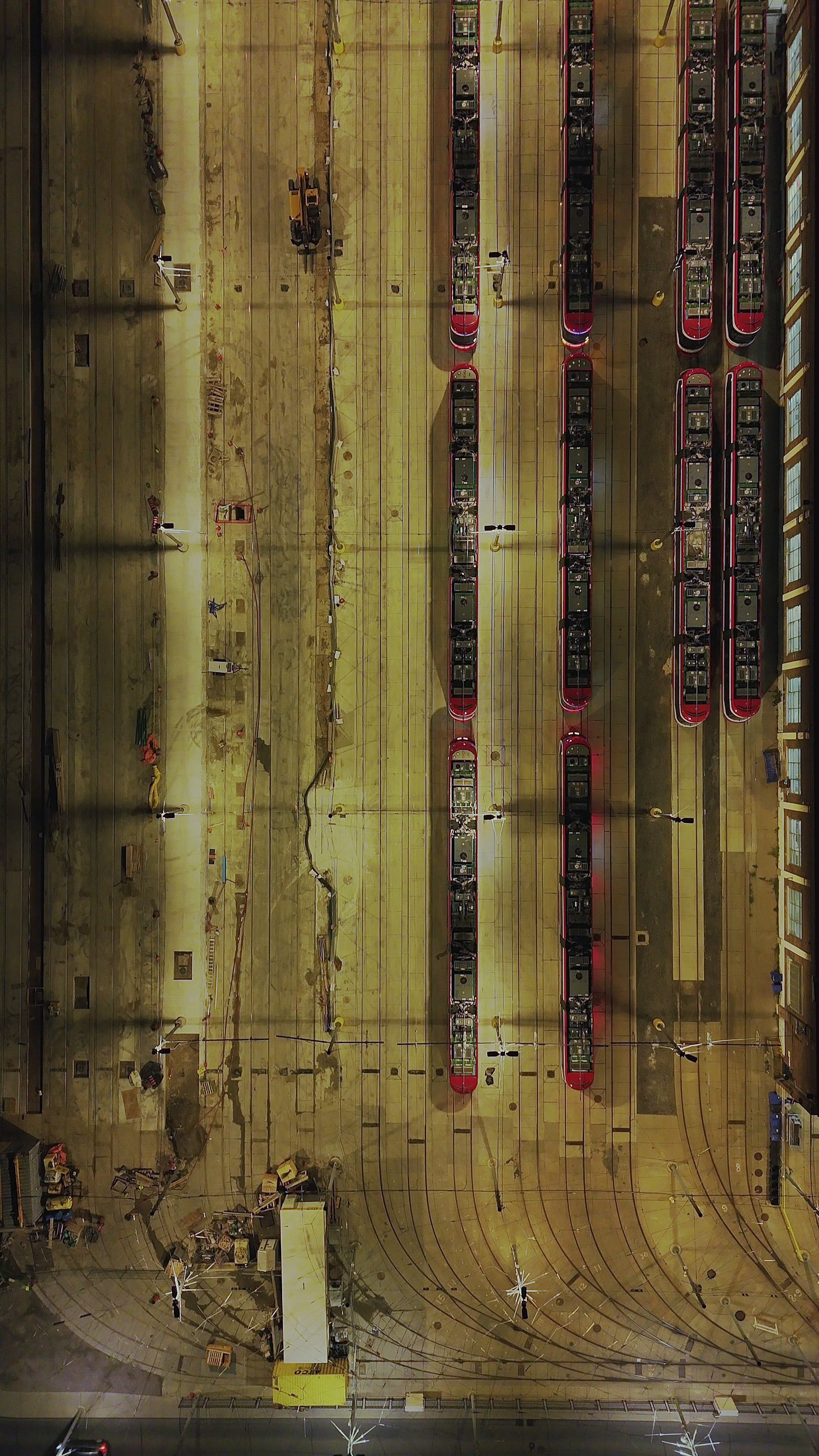 Aerial Top Down View of Tram Depot at Night with Moving Trams — Premium 4K stock footage
