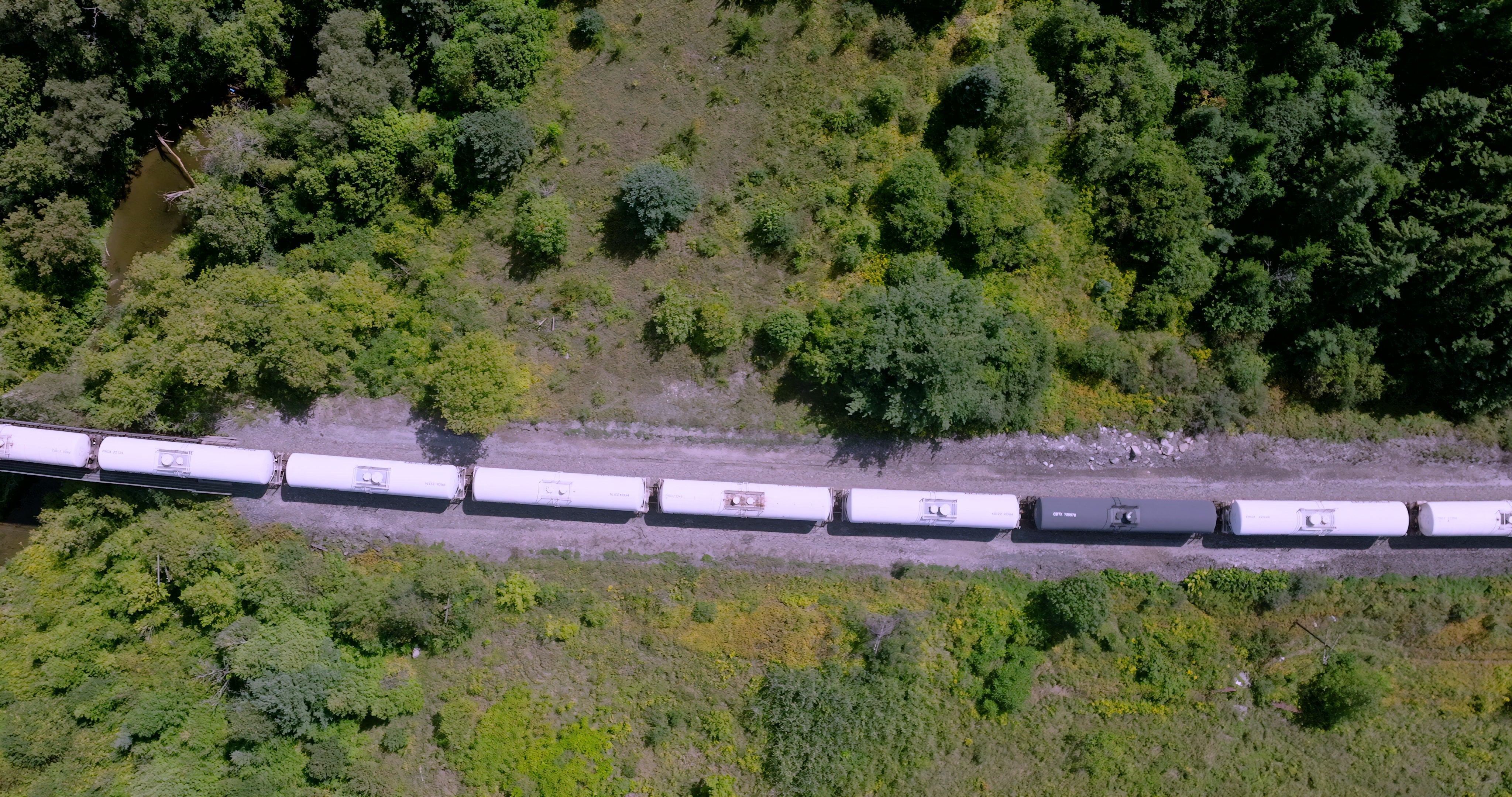 Freight Train Through Green Forest Valley - Top Down in summer — 4K stock footage