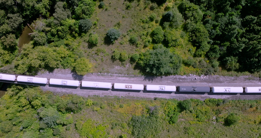 Freight Train Through Green Forest Valley - Top Down