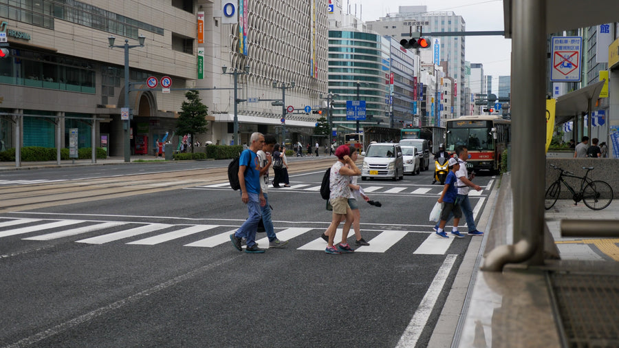Pedestrians Crossing Busy Urban Street in Japanese City