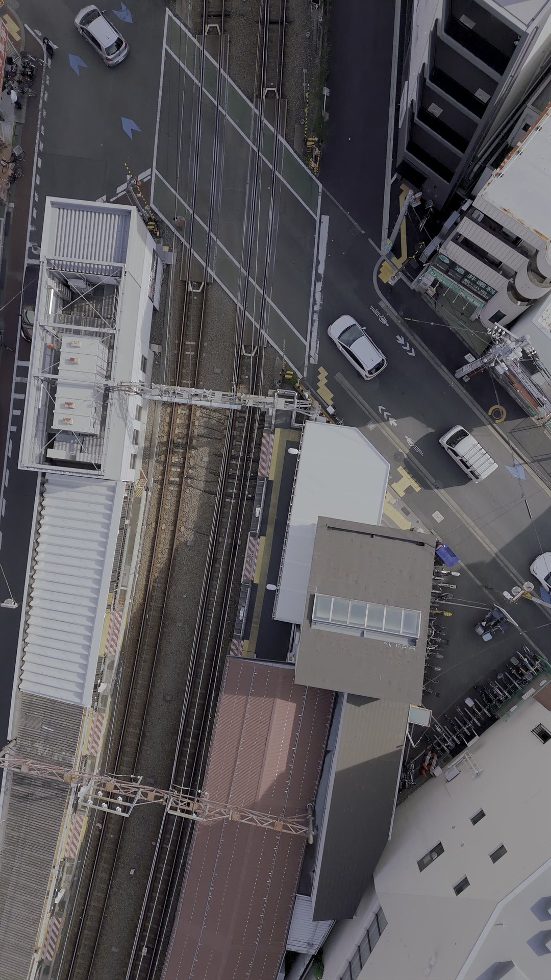 Aerial Top-Down View of Urban Street with Railway Crossing — Premium 4K stock footage