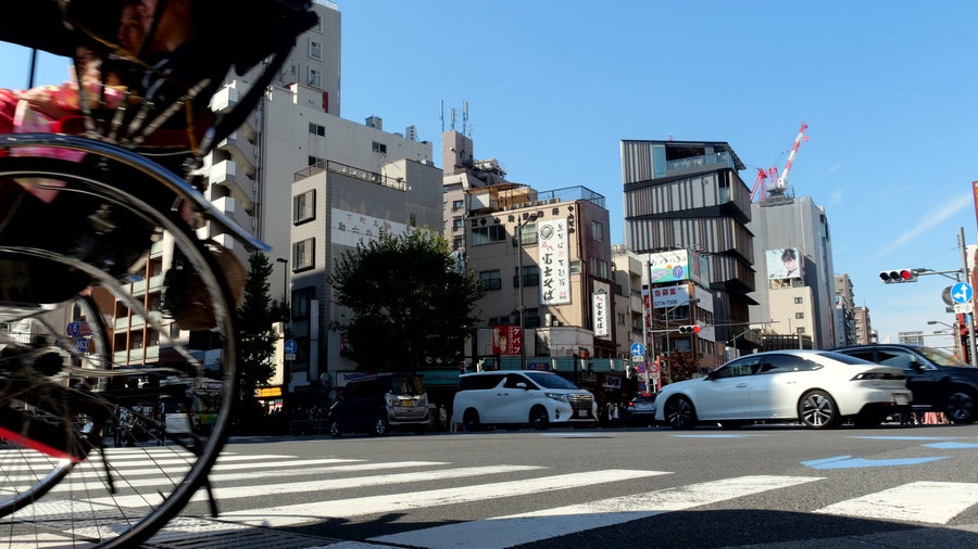 Traditional Japanese Rickshaw Crossing Busy Urban Street in Tokyo