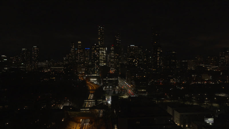 Aerial Night Cityscape with Highway Traffic and Illuminated Skyline