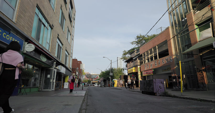 Pedestrians Walking on Urban Street with Shops and Restaurants