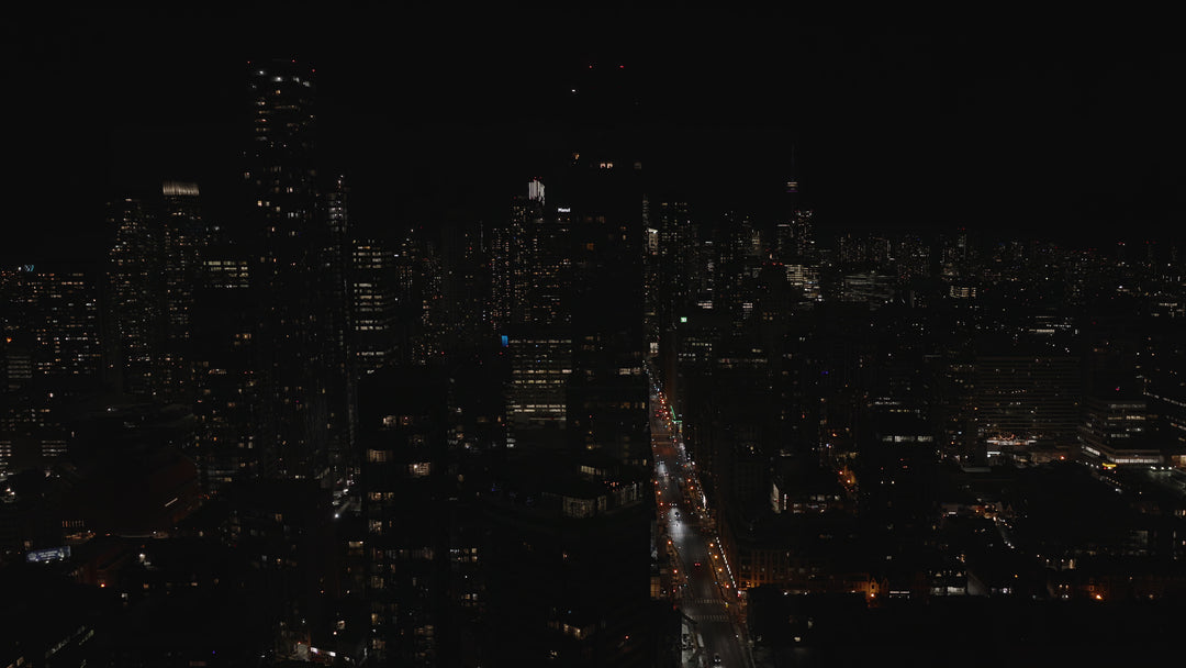 Aerial View of City Skyline at Night with Traffic on Illuminated Street — Premium 4K stock footage