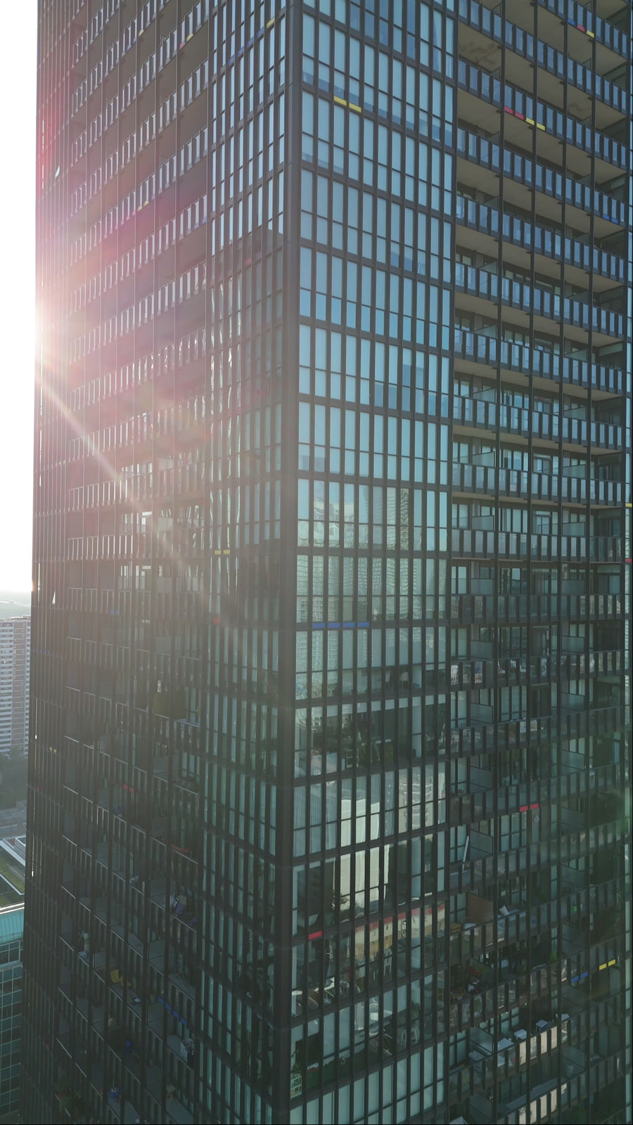 Modern Glass Skyscraper with Sun Flare at Golden Hour
