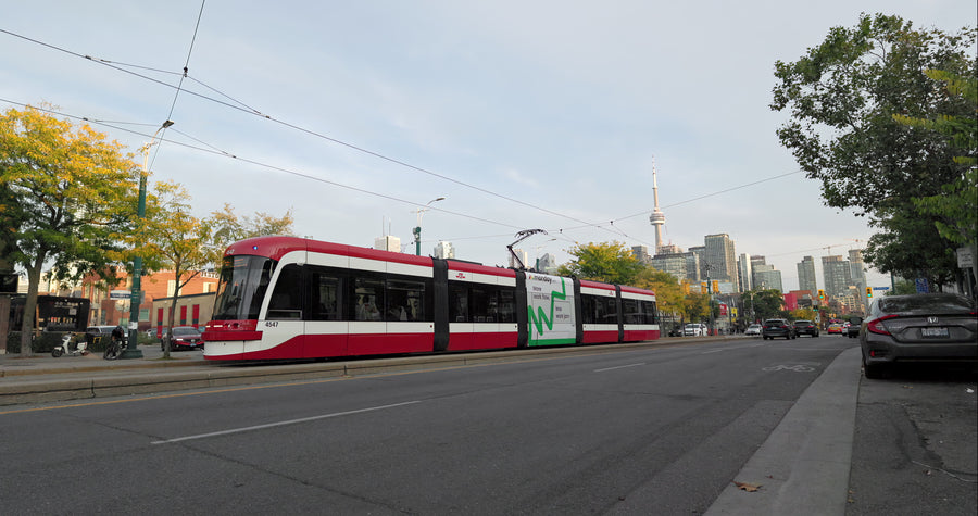 Toronto Streetcar Passing Through Urban Street with CN Tower Skyline