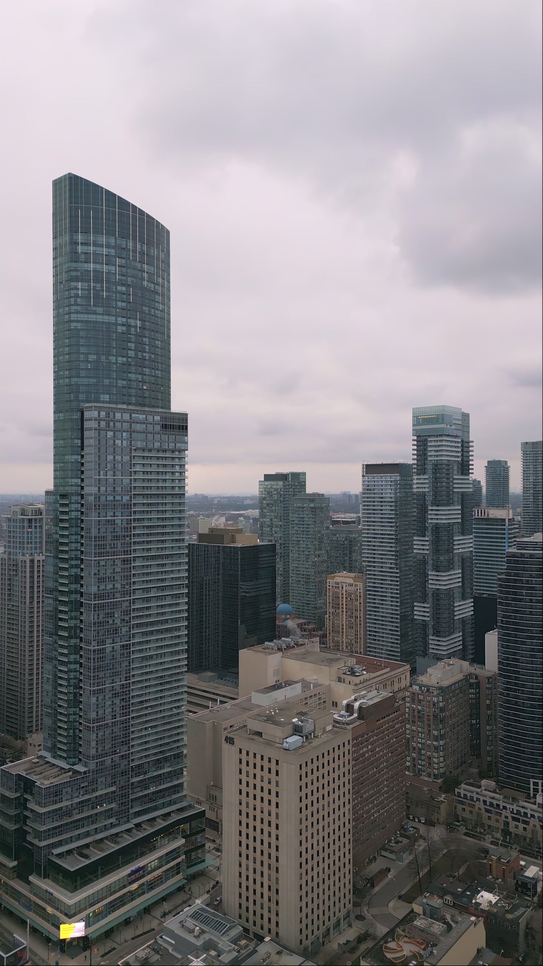 Aerial View of Modern Downtown Skyline with Glass Skyscrapers Under Overcast Sky — Premium 4K stock footage