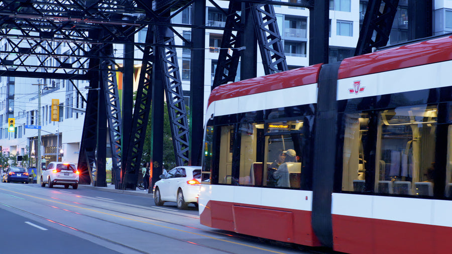 Modern Red Tram Crossing Historic Steel Bridge at Dusk