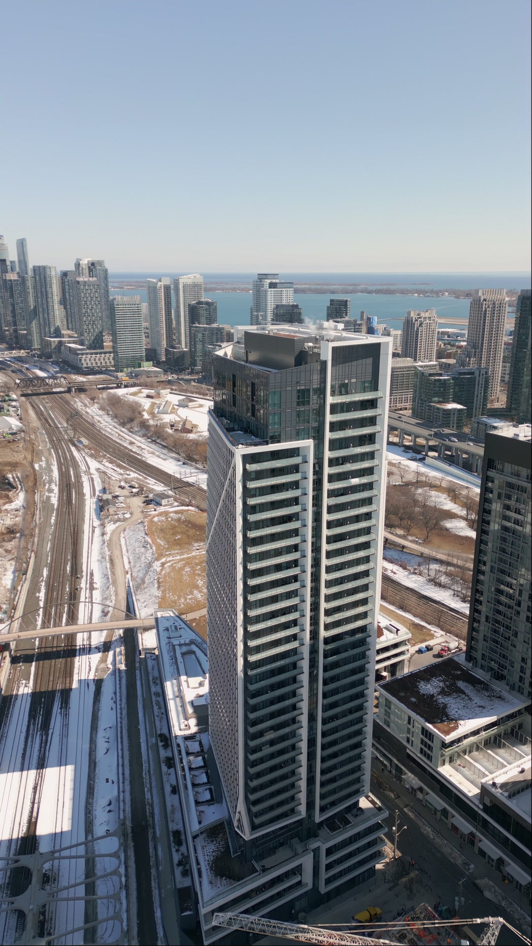 Aerial View of Modern Skyscraper and Winter Cityscape with Lake — Premium 8K stock footage