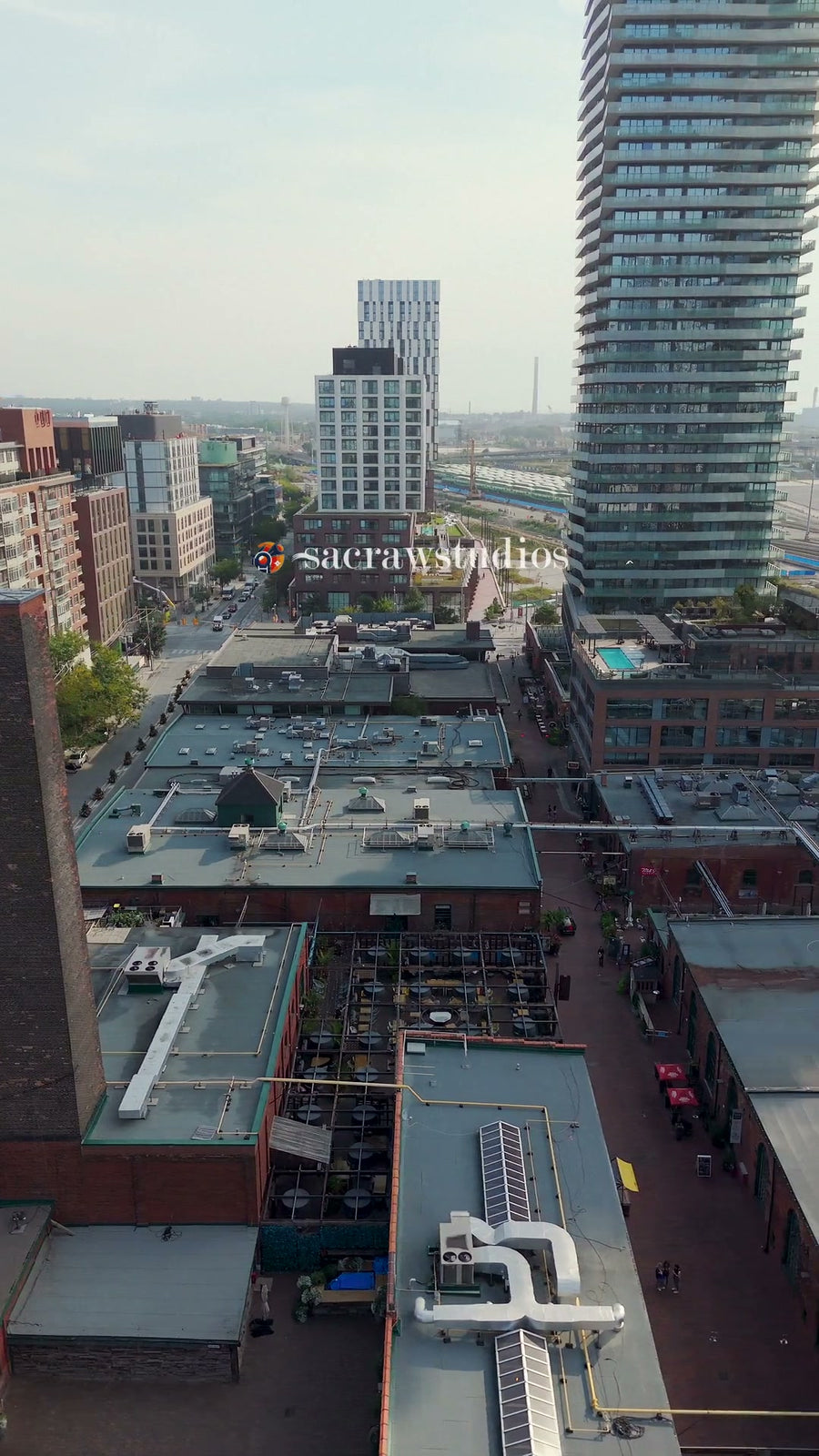 Industrial Rooftops with City Skyline - Pan Aerial